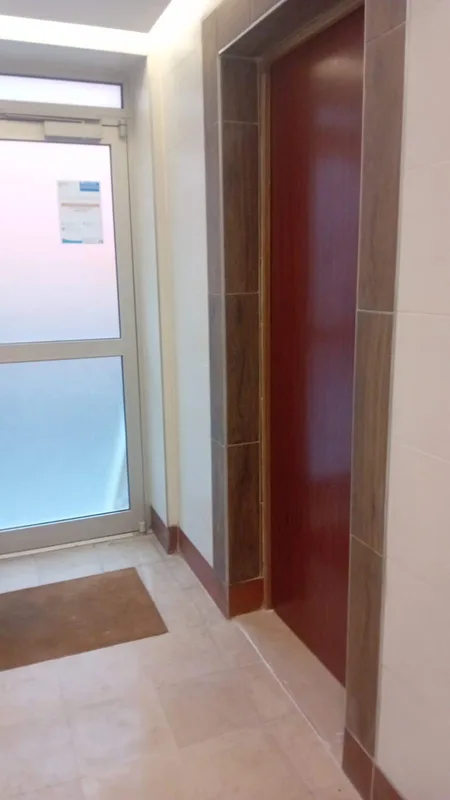 Porte palière en bois rénovée dans un hall d'immeuble